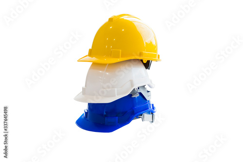 Yellow, white and blue helmets stacked on a white background, personal protective equipment concept.