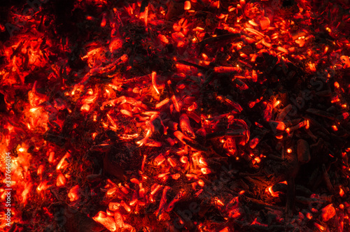Hot coals flicker in the dark.