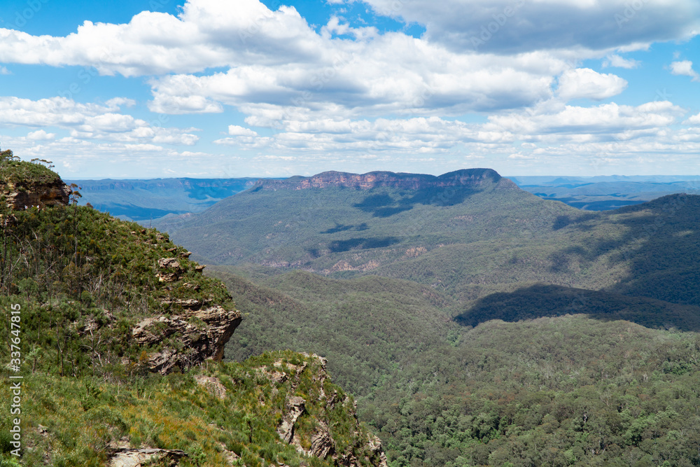 Naklejka premium Panoramic Blue Mountains Australia. Dramatic views of peaks, rock, valley, landscape, green rainforest jungle. Adventure, freedom, fun concepts. Tourist mountain trek. Shot in Sydney, NSW.