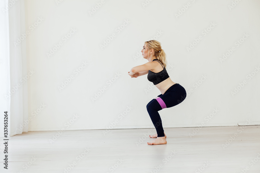 Blonde woman sports in gym with fitness gum Blonde woman sports in gym with fitness gum