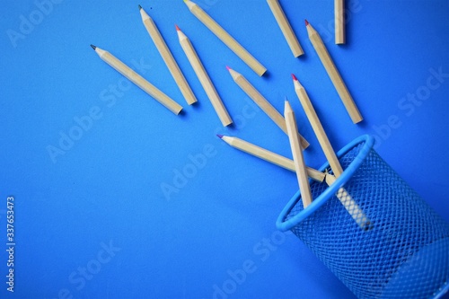 Fallen colored pencils on blue background