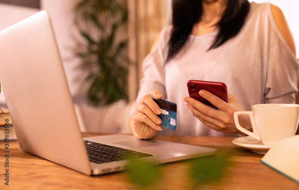 Woman is holding credit card and using laptop computer. Online shopping concept. Woman is holding credit card and using laptop computer. Online shopping concept.