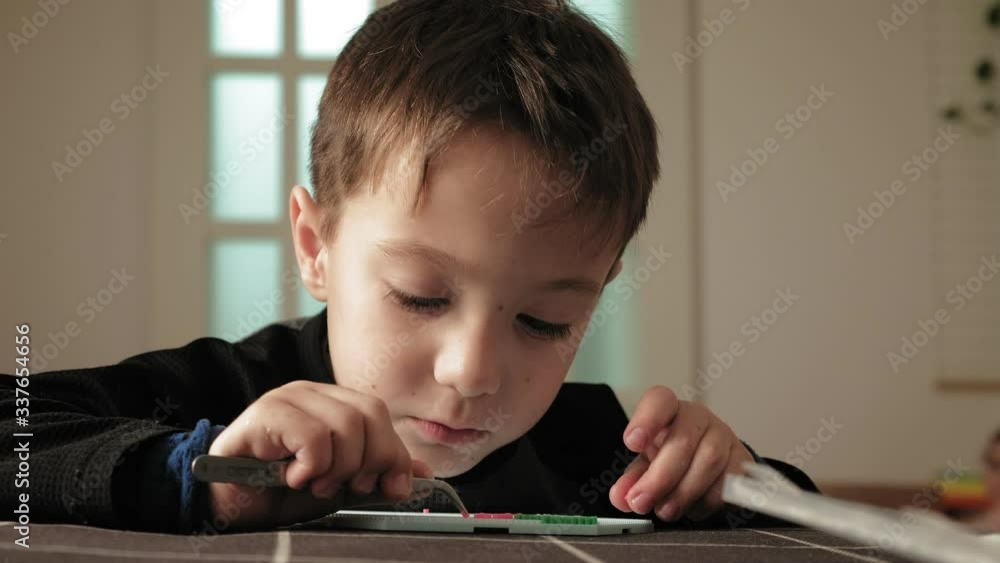 child plays with perler beads. fine motor development child plays with perler beads. fine motor development