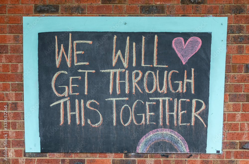 Chalk sign saying we will get through this together on a brick wall.  Written during the Coronavirus pandemic lockdown. - obrazy, fototapety, plakaty 