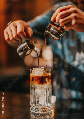 Iced americano preparation, pouring coffee into iced glass