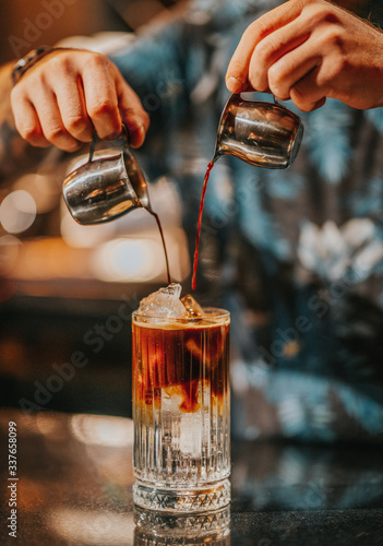 Iced americano preparation, pouring coffee into iced glass