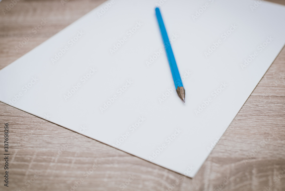 Blank white paper with a pencil on a wooden table. Blank white paper with a pencil on a wooden table.