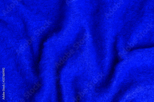 macro photography of a blue soft fluffy woolen knitted blanket. the texture of the fabric creates beautiful shapes. Blue Angora goat hair or the texture of the mohair. Close-up, selective focus.