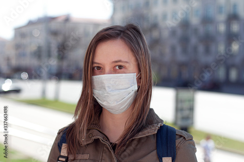 Woman in mask on street because of air pollution and epidemic in city