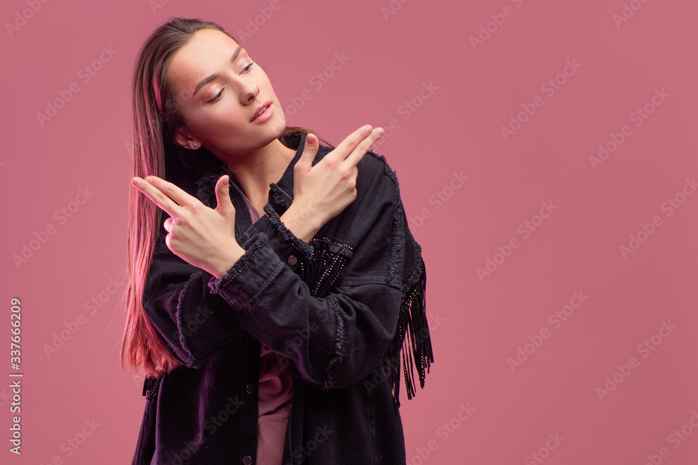 cheerful girl in a fringed jacket dances on a pink background. cheerful girl in a fringed jacket dances on a pink background.