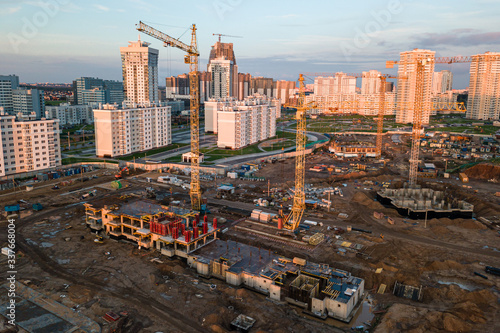 apartment building construction, cranes on sunset background