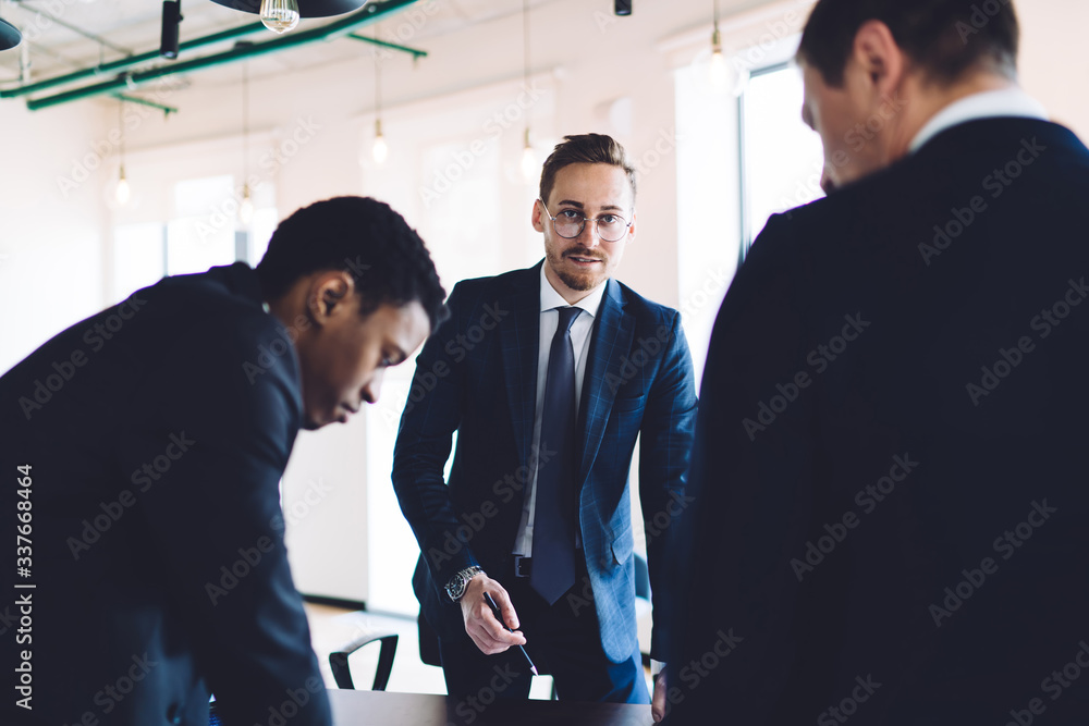 Businessman explaining plan to colleagues in office Businessman explaining plan to colleagues in office