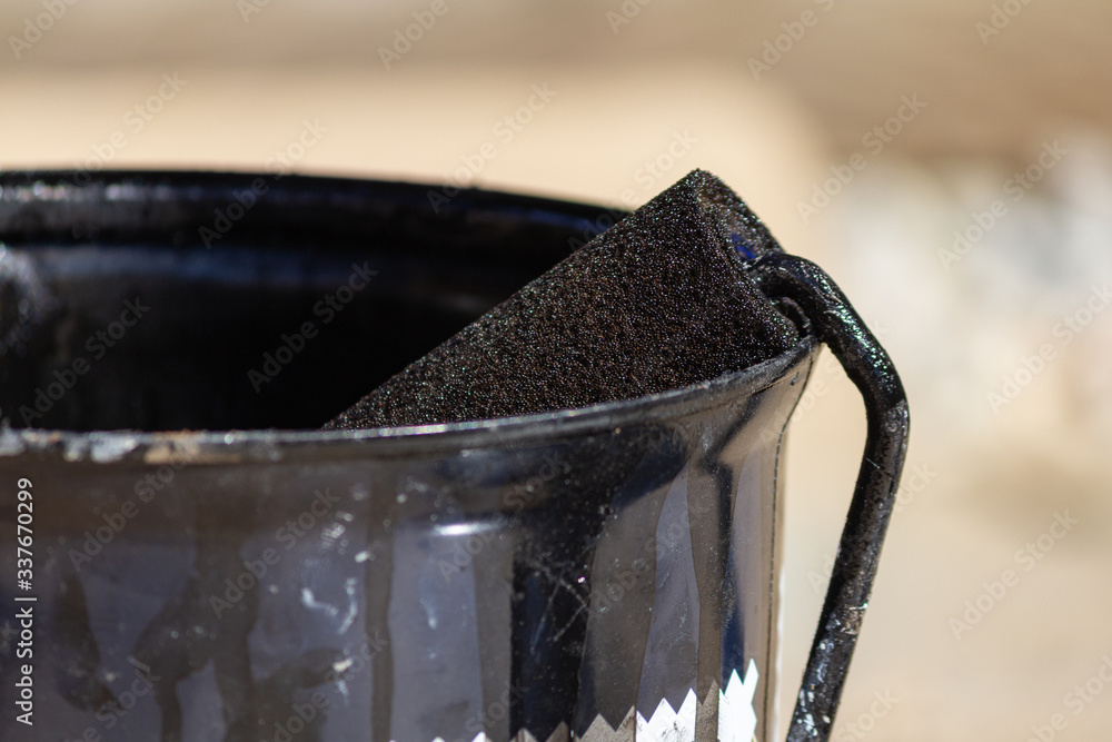 Bucket of brown paint and a roll in a closeup photo
