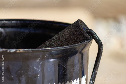 Obraz na płótnie Bucket of brown paint and a roll in a closeup photo w salonie