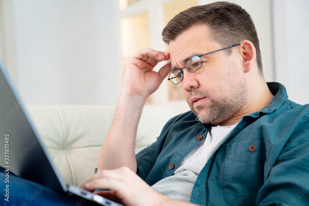 freelancer in glasses work online lying on couch freelancer in glasses work online lying on couch