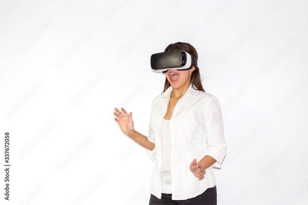 Beautiful girl uses Virtual Reality a helmet with surprise and enthusiasm Beautiful girl uses Virtual Reality a helmet with surprise and enthusiasm