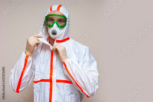 Scientist in protective gear with buttons on a suit on a light background