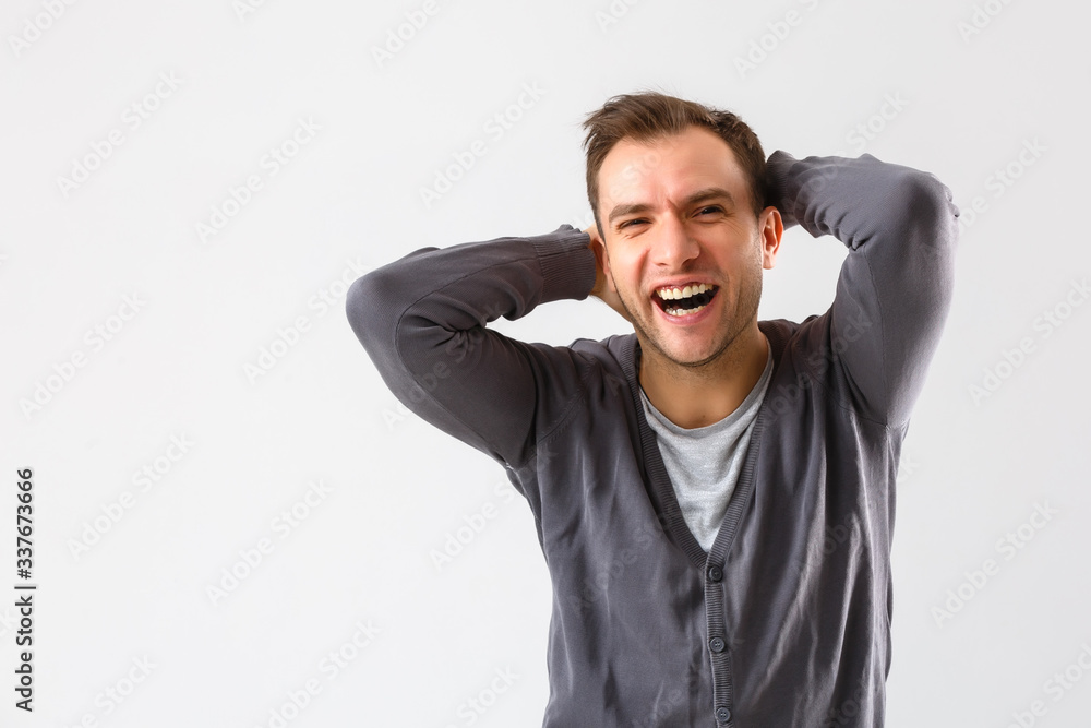 portrait emotional man standing near a wall on a gray background portrait emotional man standing near a wall on a gray background