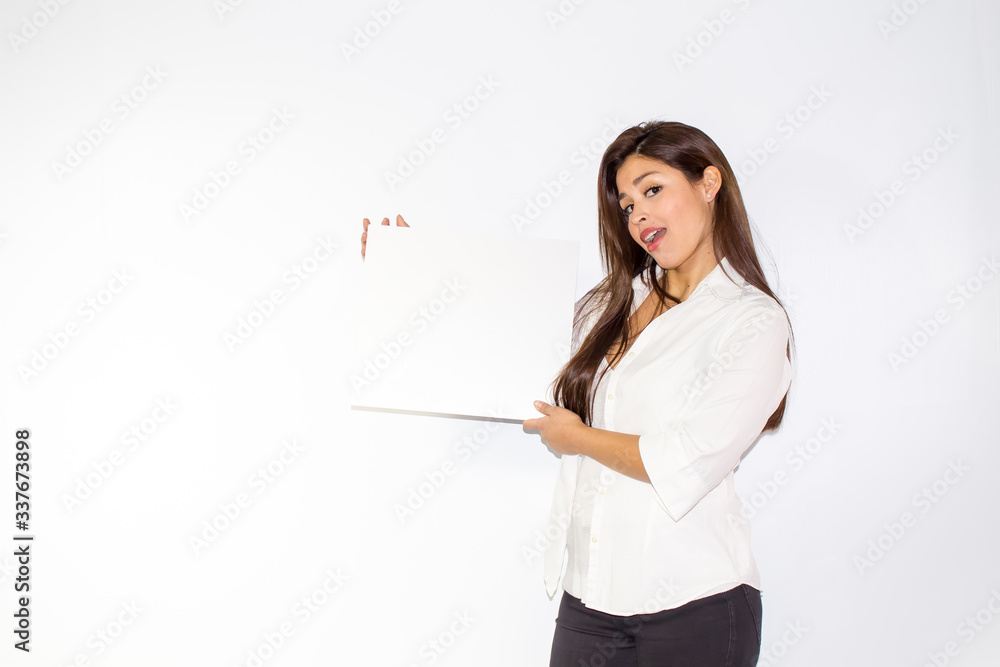 Bella ragazza bruna regge un cartello bianco su fondo bianco isolato