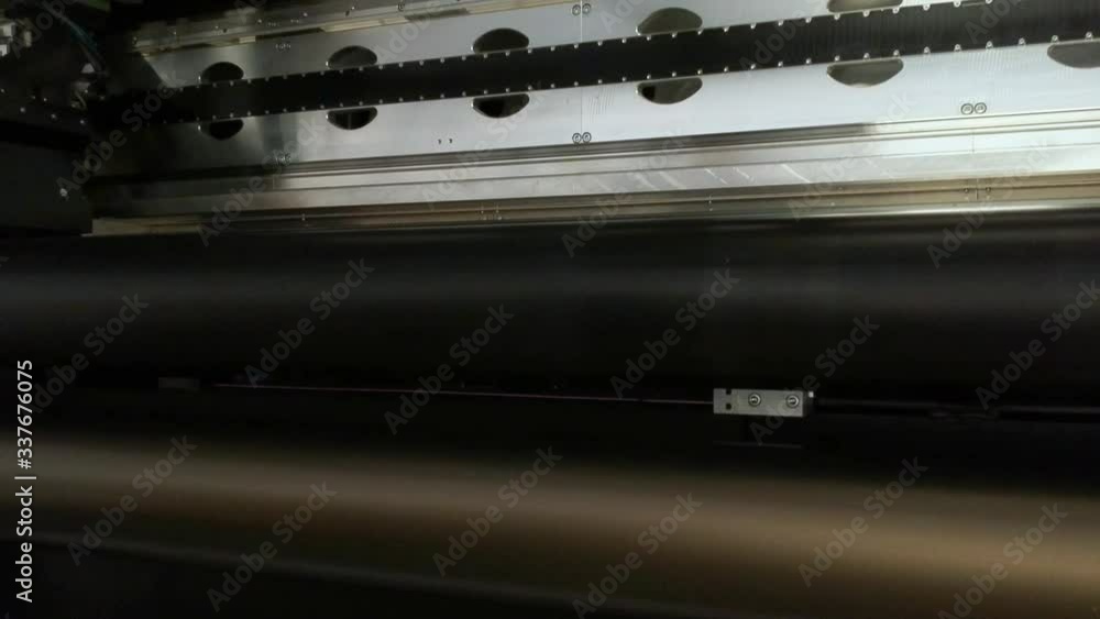 Details of a moving print head. Massive machinery. Professional printing facility, big vinyl rolls, ready for market. Glossy, matte, ecological materials used for commercial billboards and press. Details of a moving print head. Massive machinery. Professional printing facility, big vinyl rolls, ready for market. Glossy, matte, ecological materials used for commercial billboards and press.