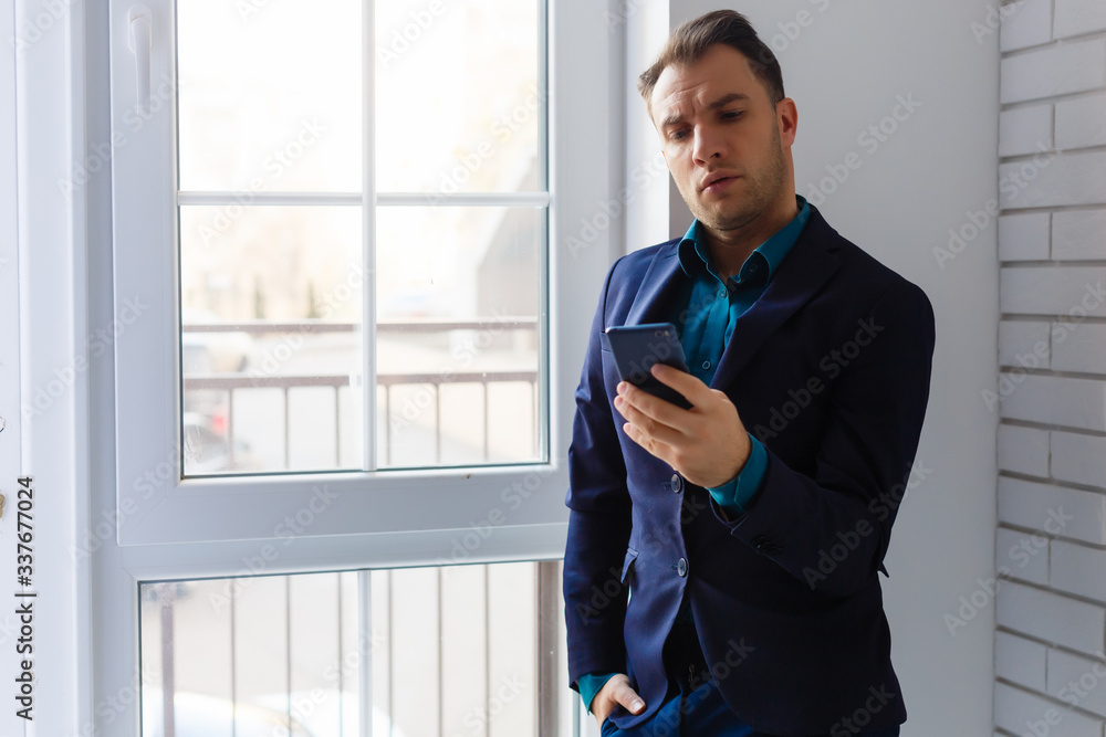 portrait of a young man standing by packages in empty office portrait of a young man standing by packages in empty office