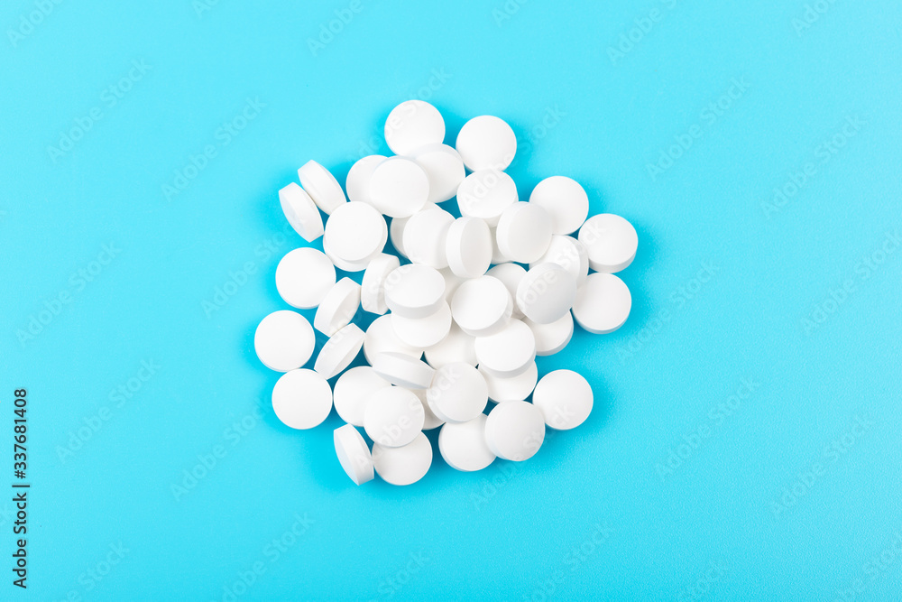 White round pills on a blue background White round pills on a blue background