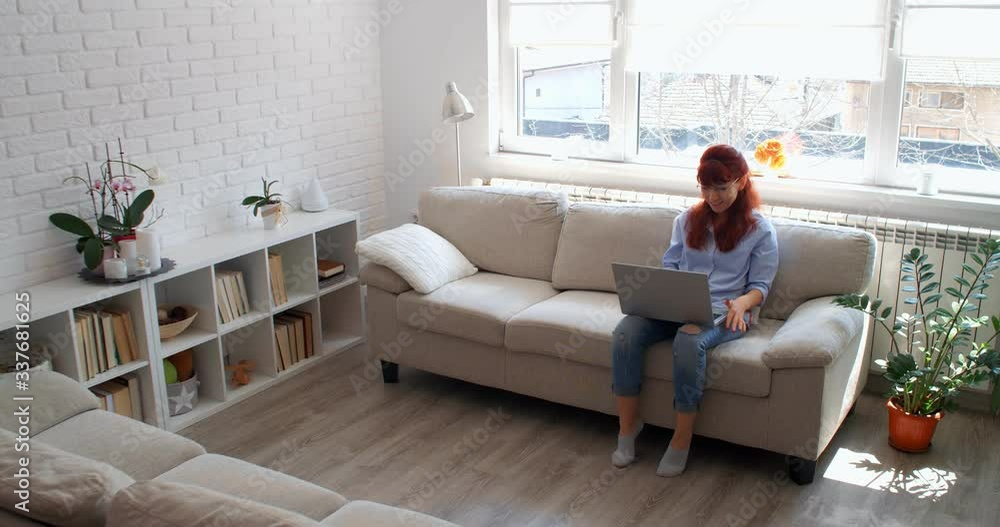 COVID-19 concept. A woman isolated at home with a laptop having a video chat with family, 4k