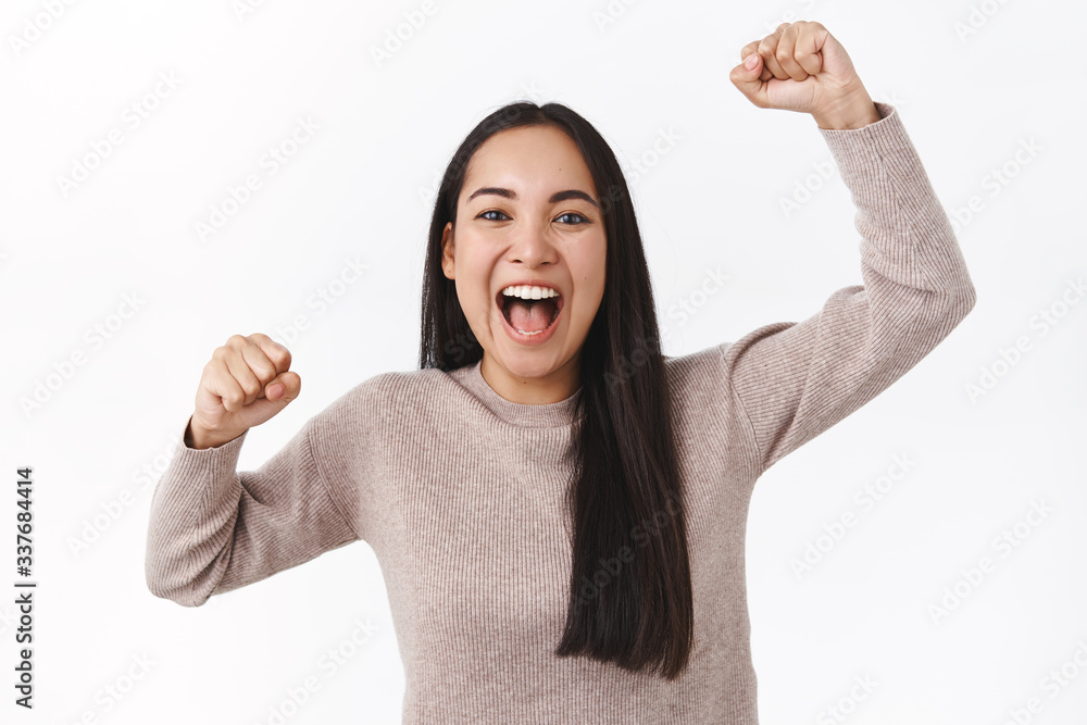 Cheerful excited asian girl rooting for football team, raising hands up, fist pump and smiling, shout from adoration and thrill, devoted fan want win. Woman triumphing as become champion competition Cheerful excited asian girl rooting for football team, raising hands up, fist pump and smiling, shout from adoration and thrill, devoted fan want win. Woman triumphing as become champion competition