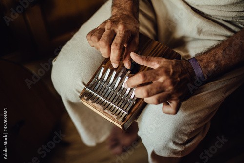 Close up photo of hands of an Indian musician playing kalimba