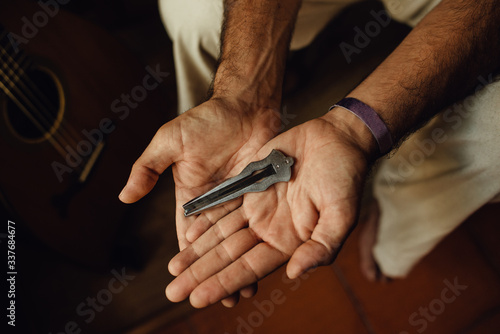 Hands of a musician holding a Jew's harp, or vargan