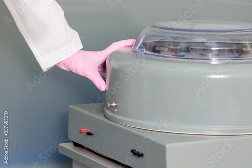 Doctor uses centrifuge machine in medical clinic. photo