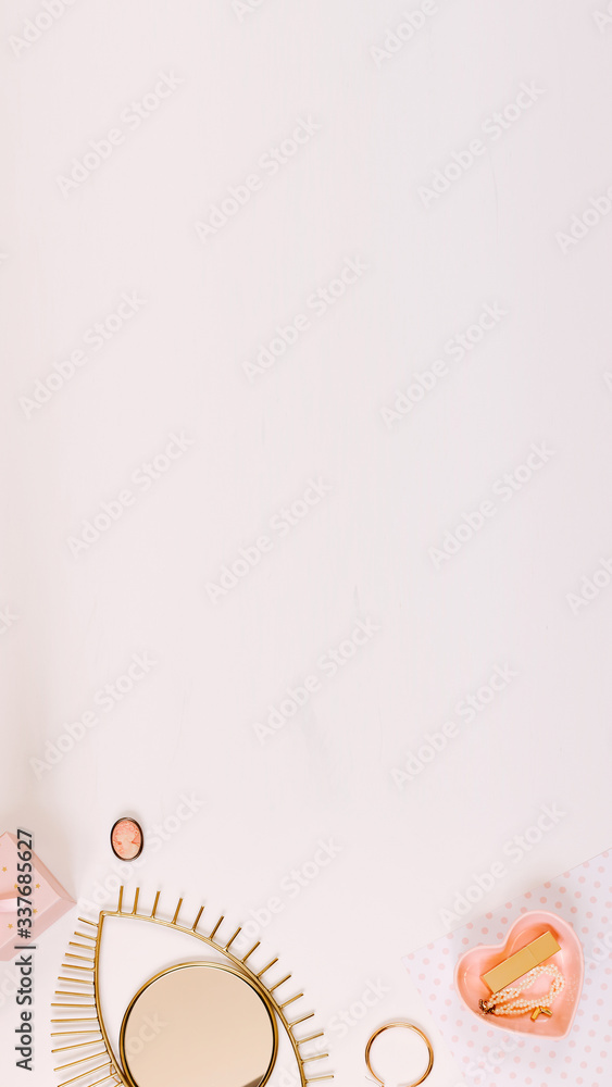 Vertical picture. Women workplace with pink daily planner, earrings, pen and heart shaped plate on white desk in flat lay style. Copy space, overhead view Vertical picture. Women workplace with pink daily planner, earrings, pen and heart shaped plate on white desk in flat lay style. Copy space, overhead view