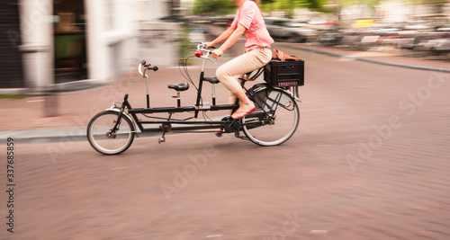Photography Woman riding a double passenger bicycle in Amsterdam
