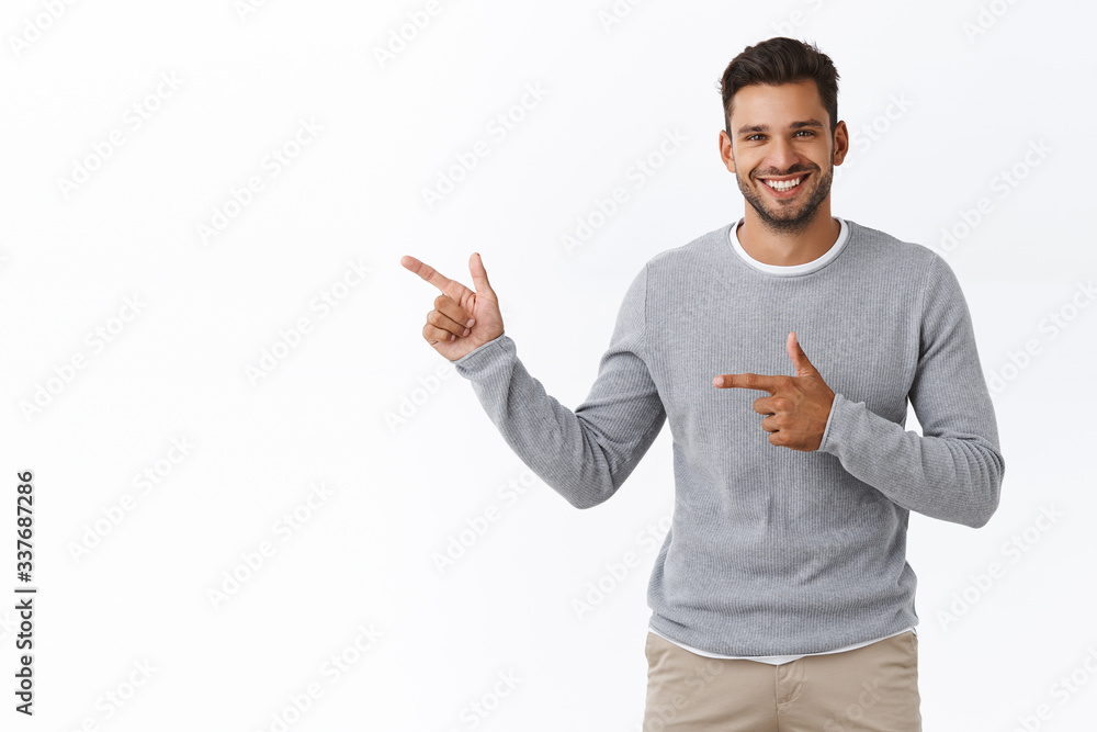 Good-looking charming bearded caucasian guy with short stylish hairstyle, wear grey sweater, pointing left, advertise product, corporate promotion, give advice or recommendation, smiling pleased Good-looking charming bearded caucasian guy with short stylish hairstyle, wear grey sweater, pointing left, advertise product, corporate promotion, give advice or recommendation, smiling pleased