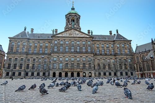 City scenic from Amsterdam on the Dam square with doves instead of tourists during the Corona crisis in the Netherlands photo