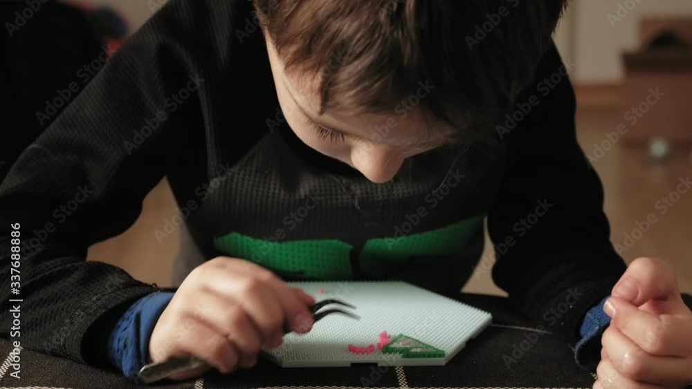 child plays with perler beads. fine motor development child plays with perler beads. fine motor development