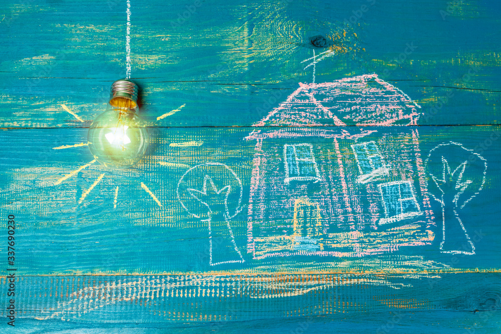 energy saving light bulb and house drawn on wooden boards. Drawing with chalk.