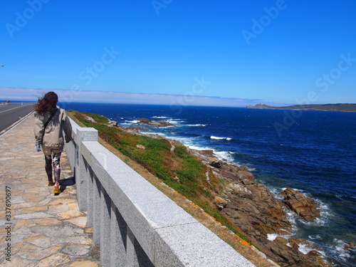 Pilgrim walking by beautiful blue sea, Camino de Santiago, Way of St. James, Journey from Dumbria to Muxia, Fisterra-Muxia way, Spain