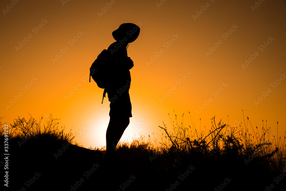 Silhouette of a womanwith a backpack in thesunset. Silhouette of a womanwith a backpack in thesunset.