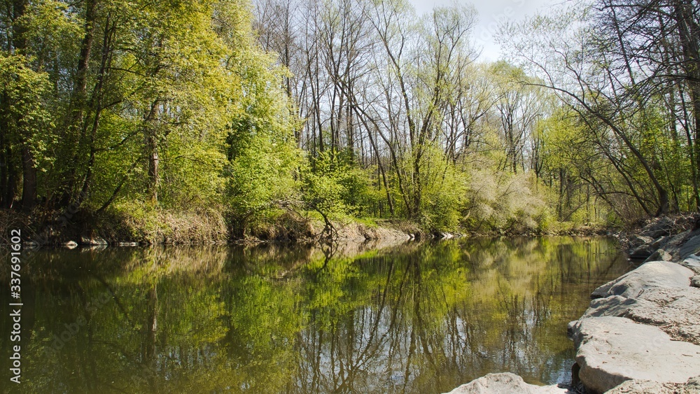 Flusslandschaft bei gutem Wetter, die Landschaft spiegelt sich im Wasser