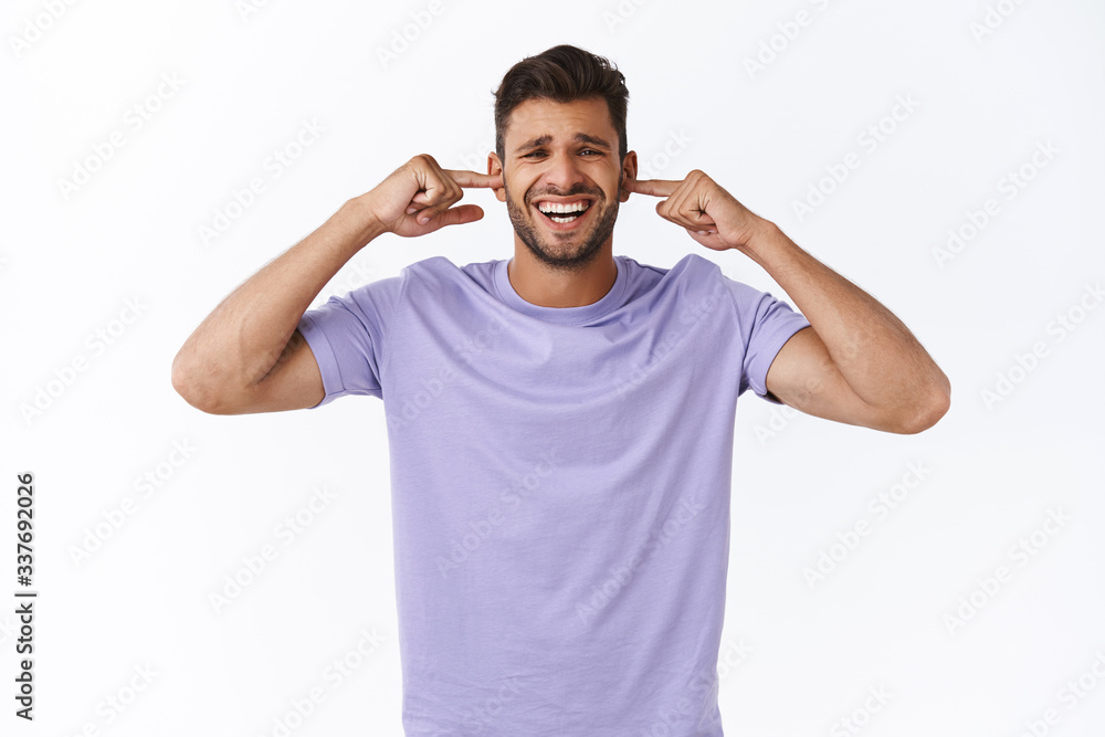 Bothered and fed up sad, upset bearded guy cant work in loud atmosphere, close ears with fingers, grimacing discomfort, disturbed by annoying awful noise, asking turn off music, white background Bothered and fed up sad, upset bearded guy cant work in loud atmosphere, close ears with fingers, grimacing discomfort, disturbed by annoying awful noise, asking turn off music, white background