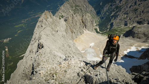 Tourist with equipment on the via ferrata trail in the alps