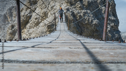 Tourist on the suspension bridge in Monte Cristallo, Dolomite Alps, Italy