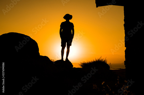 Silhouette of a womanwith a backpack in thesunset. photo