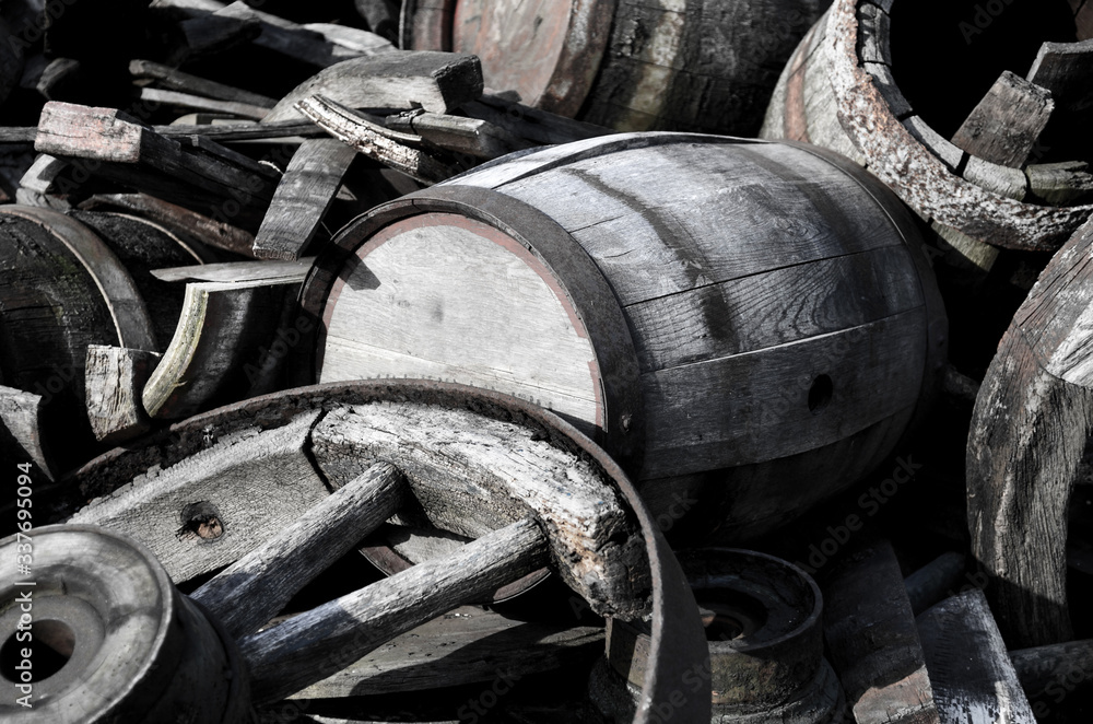 Abstract image with old wooden barrels of alcohol and wheels from the cart