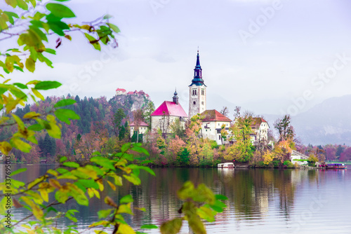 Obraz na płótnie Magical autumn landscape with church on island on Lake Bled (Blejsko jezero), Julian Alps, Slovenia. Amazing places. Popular tourist atraction. Places of pilgrimage. (Meditation, harmony - concept) w salonie