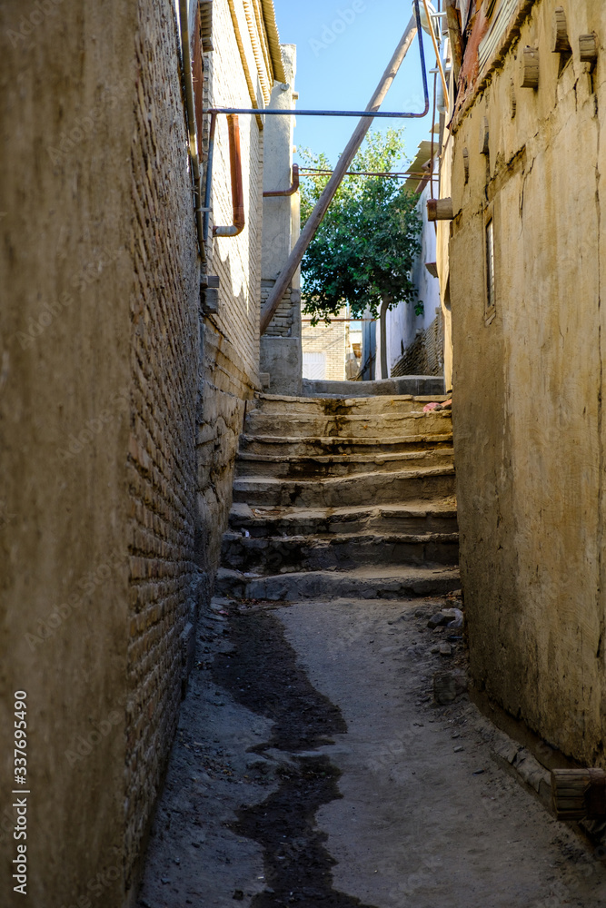 Narrow ancient pedestrian street with stairways in old town. Central Asia travel view