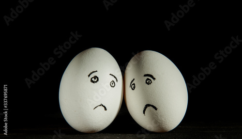 two sad eggs on a black background