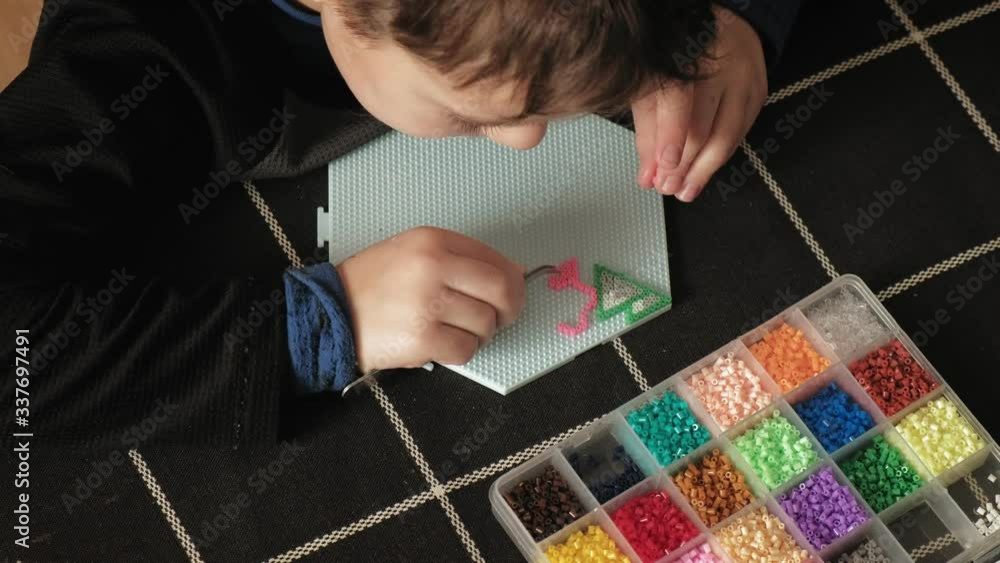 child plays with perler beads. fine motor development child plays with perler beads. fine motor development