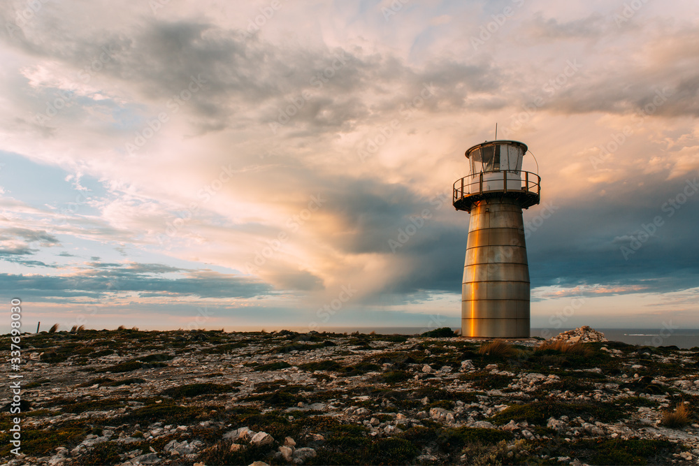 Lighthouse with dramatic clouds before sunset